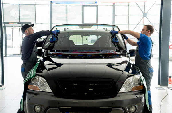 two men installing a windshield
